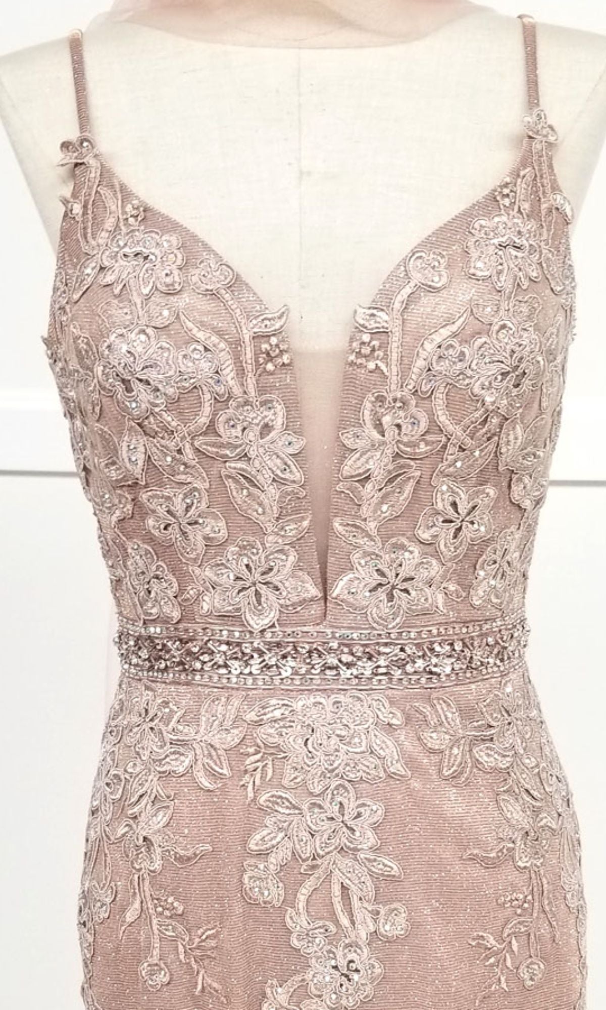 Close-up of the Chicas C243 low-back long mermaid prom dress, featuring a sleeveless blush pink design with floral lace embroidery, beads, and a deep V-neckline displayed on a dress form.